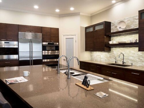 Tulsa kitchen remodel featuring bamboo cabinets, a Galley Workstation, a Wolf induction cooktop, quartz counters, an undermount sink, tall storage with a Wolf steam oven, and a Sub-Zero French door refrigerator.