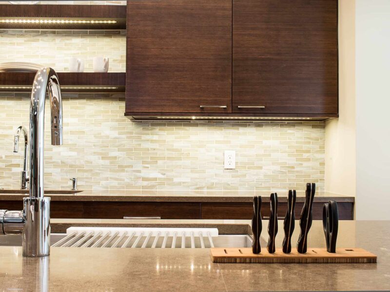 Tulsa kitchen design and remodel featuring a contemporary kitchen with bamboo cabinets, a kitchen island with a Galley Workstation and recessed knife block, an undermount sink, and open shelves.
