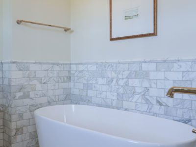 Freestanding master bathroom tub, floor mounted faucet, wainscot subway tile backsplash Tulsa master bathroom remodel