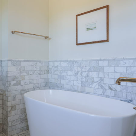Freestanding master bathroom tub, floor mounted faucet, wainscot subway tile backsplash Tulsa master bathroom remodel