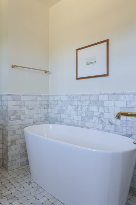 Freestanding master bathroom tub, floor mounted faucet, wainscot subway tile backsplash Tulsa master bathroom remodel