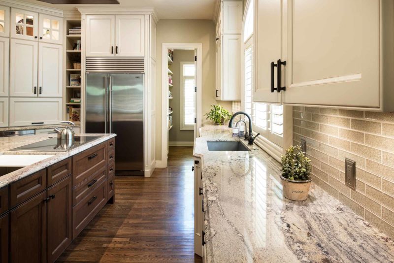 Kitchen island cabinet storage, marble counter-tops, Wolf induction cooktop, undermount sink, subway tile backsplash, Sub-Zero full size freezer refrigerator, open shelves Tulsa kitchen remodel