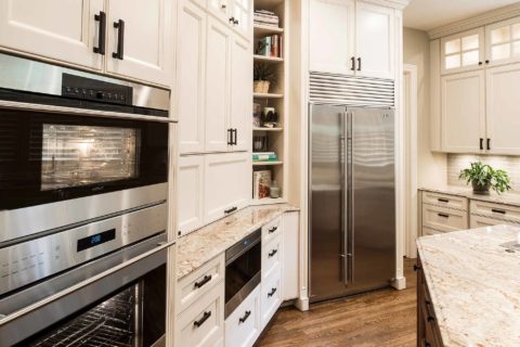 Kitchen remodel tall storage, Wolf double ovens, Wolf drawer microwave, cream painted cabinets, open shelves, Sub-Zero side-by-side freezer refrigerator Tulsa kitchen remodel