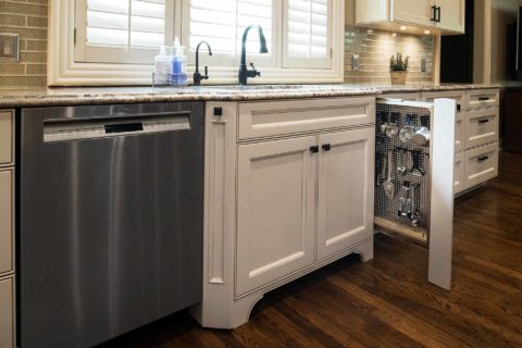 Pullout kitchen storage, stainless steel dishwasher, sink base cabinet drawer storage, cream cabinets, undermount sink Tulsa kitchen design and remodel