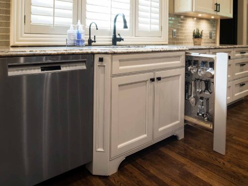 Pullout kitchen storage, stainless steel dishwasher, sink base cabinet drawer storage, cream cabinets, undermount sink Tulsa kitchen design and remodel