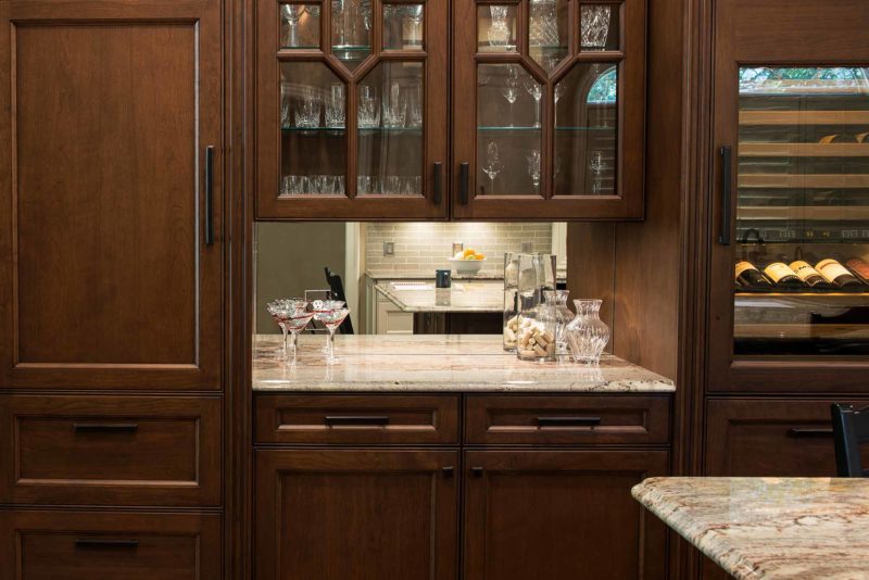 Tulsa kitchen beverage center Sub-Zero tall wine refrigerator, brown cabinetry, mirror backsplash, wood panel Sub-Zero freezer refrigerator Tulsa kitchen design and remodel