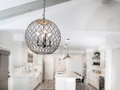 Tulsa kitchen pendant lights, adjoining living room, luxury vinyl wood flooring, white cabinet base wall storage, large kitchen island, Galley Workstation, stainless appliances Tulsa kitchen remodel