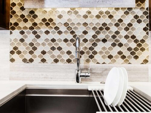 Tulsa kitchen remodel featuring a Galley Workstation clean-up sink, decorative tile backsplash, and Caesarstone countertop.
