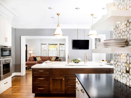 Midtown Tulsa kitchen design and remodel featuring a kitchen island with a Galley Workstation, red birch cabinet and drawer storage, pendant lights, an Ann Sacks tile backsplash, and floating shelves.
