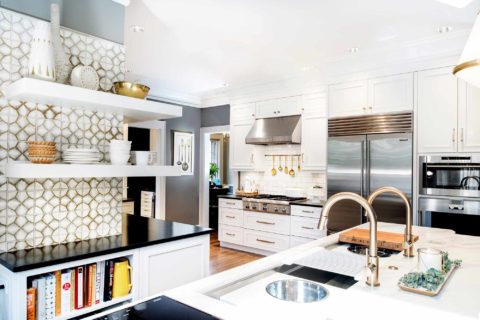 Midtown Tulsa kitchen remodel featuring a kitchen island with a Galley Workstation, white marble countertops, an induction cooktop, open shelves with cookbook storage, and an Ann Sacks tile backsplash.