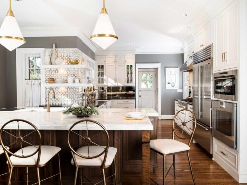 Tulsa kitchen remodel featuring a Galley Workstation, island seating, pendant lights, refinished wood floors, a decorative Ann Sacks backsplash, and professional appliances.