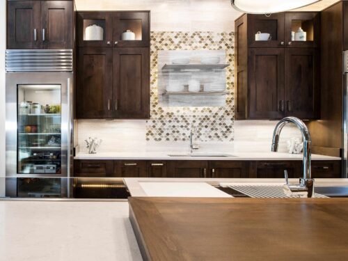 Tulsa kitchen remodel featuring a Galley Workstations, Wolf induction cooktop, open shelves, a tile backsplash, and Sub-Zero tall refrigerators.