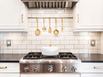Traditional Tulsa kitchen including stainless Thermador gas rangetop and vent hood accented by white subway tile backsplash.