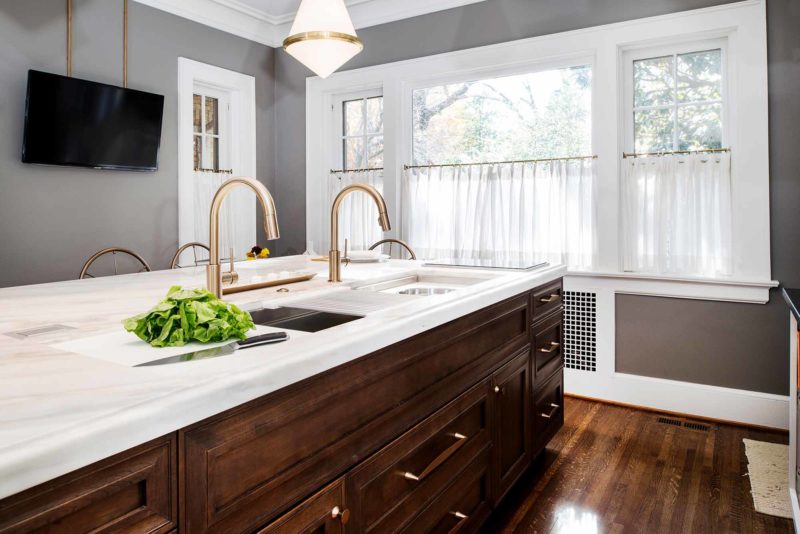 Beautiful Tulsa kitchen remodeled and designed with a Galley Workstation large kitchen sink and large island with red birch cabinet storage, white marble counter top and induction cooking