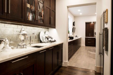 Walk-in bar space with bar sink, rich brown cabinetry, tile backsplash, quartz counter top open to Tulsa homeowner kitchen remodel