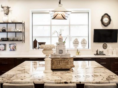 Classy Tulsa kitchen remodel with marble counter-tops, island seating, rich brown base cabinet storage, decorative pendant lighting and open shelves