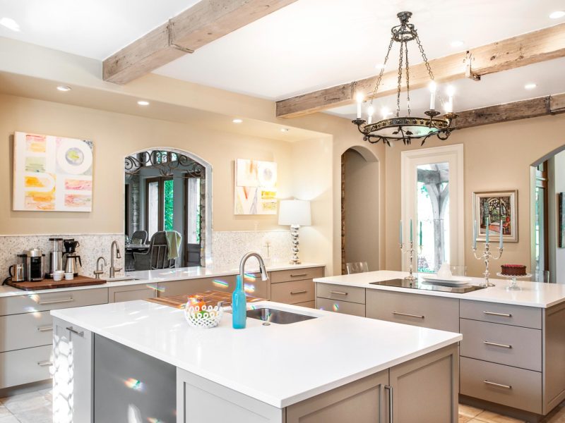 Comfy Tulsa kitchen remodel with tile floors, two islands including a beverage refrigerator, induction cooktop, coffee and beverage space, aged wood ceiling beams and rustic chandelier