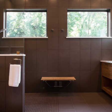 Contemporary Tulsa master bath design and remodel with walk-in shower, wood bench seating, medium brown wood grain base vanity storage, quartz counter-tops and glass partition