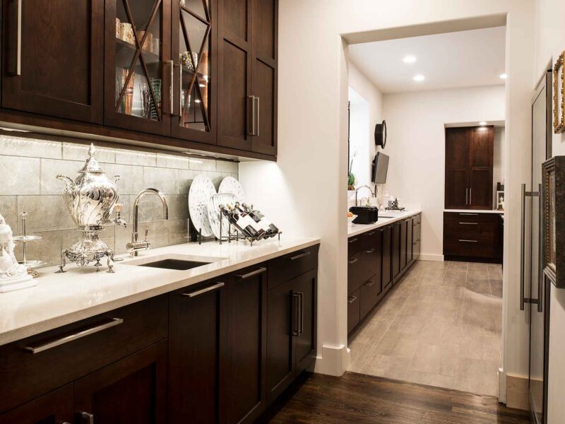 Tulsa kitchen design and remodel featuring a decorative tile backsplash and wall cabinet book storage, blending style and functionality.
