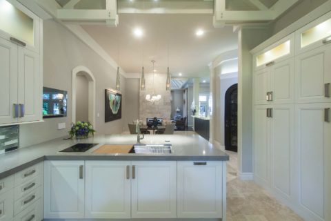 Tulsa kitchen remodel featuring a kitchen peninsula with white cabinets, a Galley Workstation, tall cabinet storage, and decorative pendant lights.