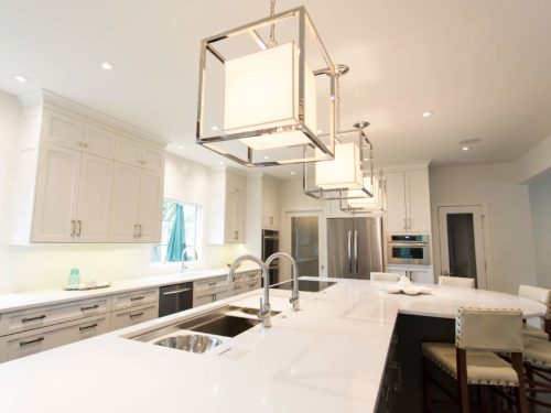 Kitchen remodel Galley sink, induction cooktop, large island seating, white cabinet storage, quartz counters, island pendants Tulsa kitchen remodel