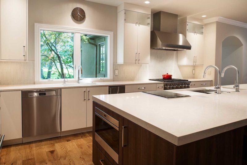 Modern functional large Tulsa kitchen with quartz counter-tops, white cabinets, stainless dishwasher, large island, drawer microwave, Wolf induction cooktop and Galley Workstation