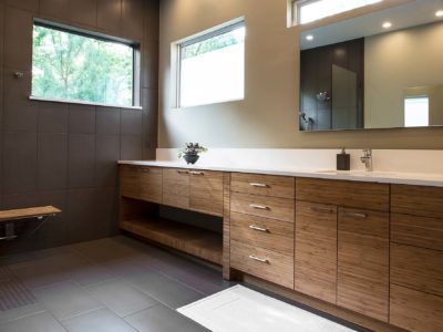 Modern Tulsa bathroom with quartz counter with backsplash, brown wood grain base cabinet storage and modern vanity mirror