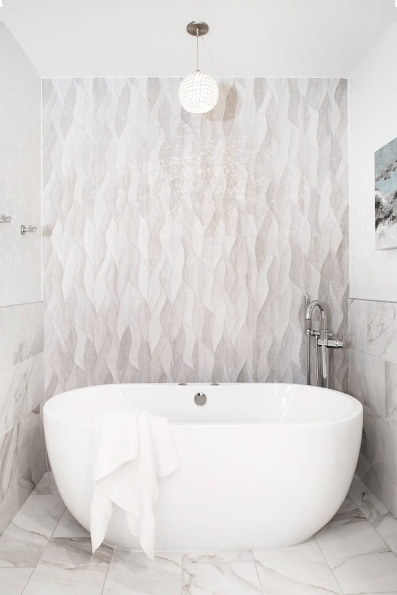 Modern Tulsa bathroom remodel with freestanding white bathtub, decorative wall tiles, chrome bath fixture and decorative ceiling light fixture