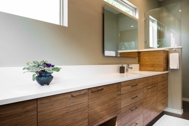 Modern Tulsa master bath, quartz counter-top, backsplash, medium brown base cabinet drawer storage, large mirror, walk-in shower and glass partition