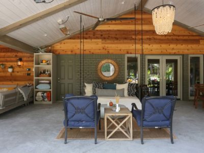 Open spacious Tulsa patio design and remodel living area with bench swing, concrete flooring and vaulted ceiling with wood paneling