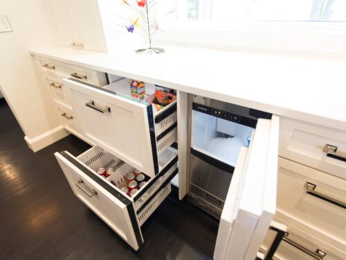 Tulsa kitchen design featuring a panel-front drawer refrigerator and ice maker, integrated into white cabinets with quartz counters.