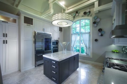 Tulsa kitchen remodel featuring tall pantry storage, island storage, Sub-Zero and Wolf stainless professional appliances, a decorative light, and a vaulted ceiling.