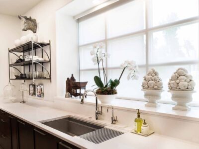 Tulsa kitchen remodel with Galley Workstation clean-up kitchen sink, quartz counter-top, decorative open shelves and rich brown wood grain cabinet storage