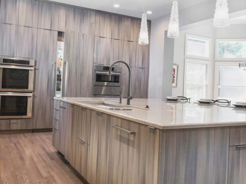 Contemporary open Tulsa kitchen design and remodel with large island storage, Galley Workstation kitchen sink, Harmoni cabinet storage and integrated refrigerator/freezer
