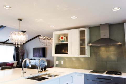 Tulsa kitchen remodel featuring a kitchen with base cabinet storage, a peninsula with a Galley sink workstation, a pendant light, quartz counters, wall cabinet storage, Bosch stainless steel appliances, a subway tile backsplash, and a vent hood.