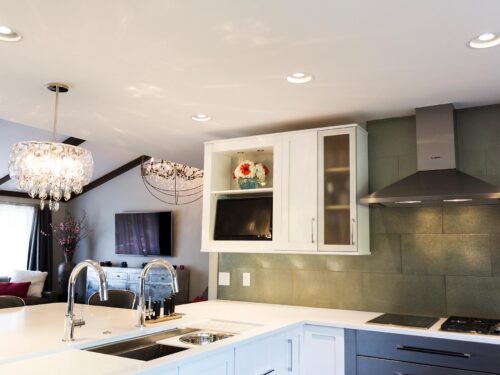 Tulsa kitchen remodel featuring a kitchen with base cabinet storage, a peninsula with a Galley sink workstation, a pendant light, quartz counters, wall cabinet storage, Bosch stainless steel appliances, a subway tile backsplash, and a vent hood.