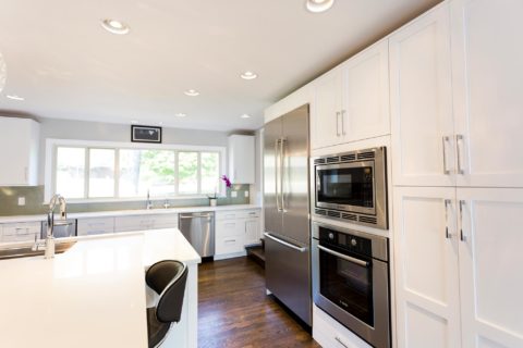 Tulsa kitchen remodel featuring a functional kitchen with tall storage, white cabinet storage, quartz counters, a Bosch French door refrigerator and freezer, a wall microwave and oven, and a tall pantry.