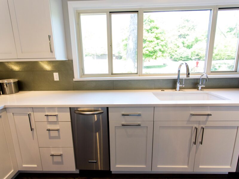 Tulsa kitchen design and remodel featuring an undermount cleanup sink, an under-counter Bosch ice maker, a dishwasher, a pullout trash, white base cabinet storage, and a subway tile backsplash.