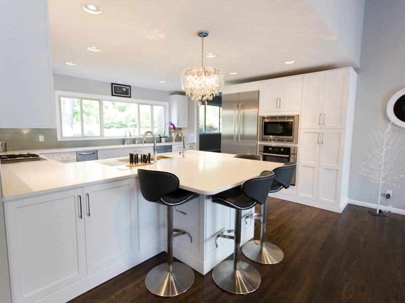 Tulsa kitchen design and remodel featuring an open kitchen with a peninsula for storage and seating, a pendant light, Bosch appliances, and wood flooring.