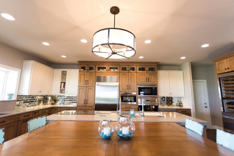 Open ranch kitchen design, large island, pendant lighting, tall storage, Sub-Zero Wolf appliances, table seating Tulsa kitchen design and remodel