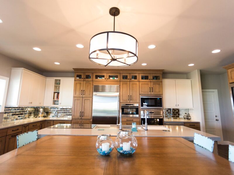 Tulsa kitchen design and remodel featuring an open ranch kitchen with a large island, pendant lighting, tall storage, Sub-Zero and Wolf appliances, and table seating.