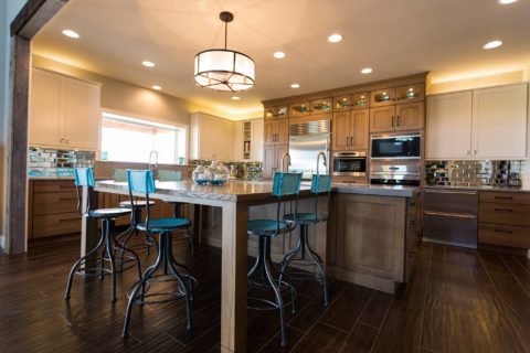 Tulsa kitchen remodel featuring an open ranch-style kitchen with a large island with seating, pendant lighting, tall cabinet storage, Sub-Zero and Wolf appliances, drawer storage, and a GalleyWorkstation.