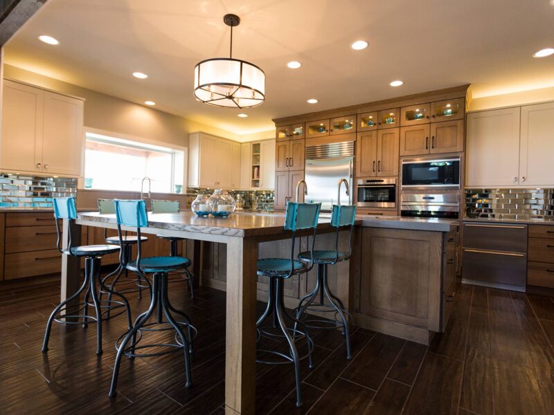 Tulsa kitchen remodel featuring an open ranch-style kitchen with a large island with seating, pendant lighting, tall cabinet storage, Sub-Zero and Wolf appliances, drawer storage, and a GalleyWorkstation.