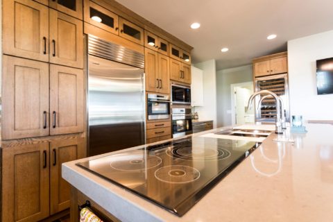 Tulsa kitchen remodel featuring tall kitchen pantry storage, Sub-Zero and Wolf appliances, an induction cooktop, and a Galley Workstation kitchen sink on an island.