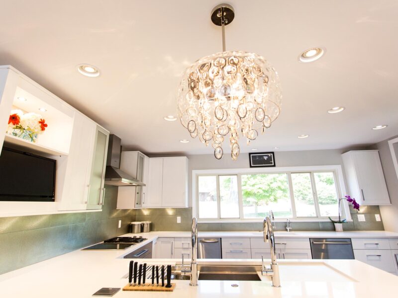 Tulsa kitchen remodel featuring a functional white kitchen with a peninsula, a Galley Workstation, a white quartz counter, a Bosch appliances, decorative pendant light, a stainless steel ice maker and dishwasher, and an undermount clean-up sink.