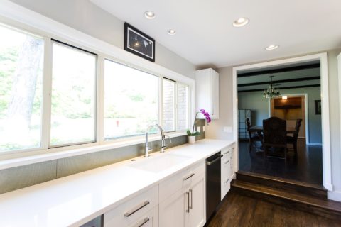 Tulsa kitchen design and remodel featuring a white kitchen with drawer storage, an undermount clean-up sink, a quartz countertop, a formal dining room entry, and wood floors.