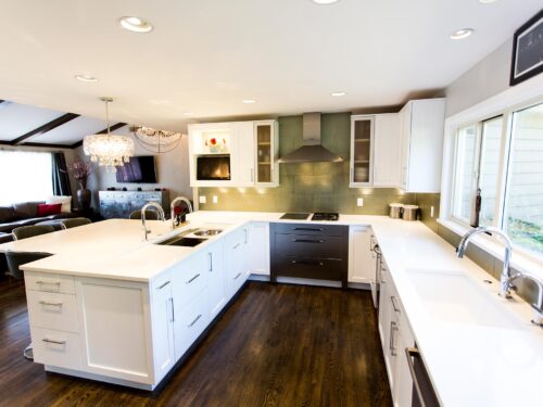 Tulsa kitchen remodel featuring a white kitchen with white cabinet storage, a peninsula with a Galley Workstation, Bosch stainless steel cooking appliances, a glass tile backsplash, an under mount clean-up sink, and quartz counters.