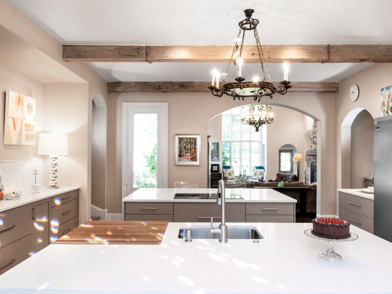 Tulsa kitchen design and remodel featuring an island with drawer storage, an induction cooktop, a prep sink with a recessed cutting board, and a full-size Frigidaire freezer and refrigerator.