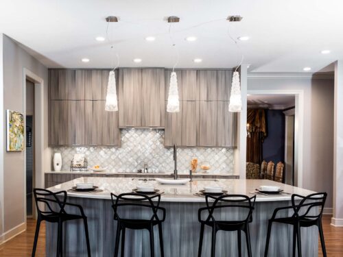 Tulsa kitchen remodel featuring an open kitchen with a large island with seating, a Galley Workstation, wood floors, Bosch stainless steel appliances, and decorative pendant lights.