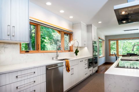 Tulsa kitchen design and remodel featuring white marble counters and backsplash, a stainless steel clean-up sink, a Bosch stainless front dishwasher, a Bosch under-counter drawer microwave, and Bosch professional stainless steel ovens.
